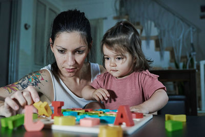 Portrait of mother and son on table at home