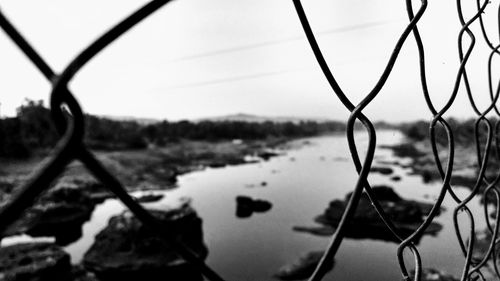 Close-up of chainlink fence against sky