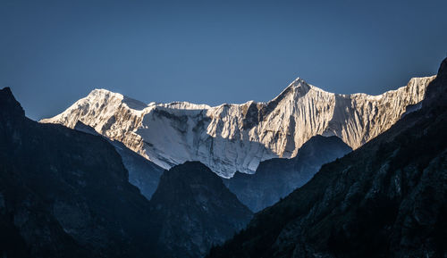 Scenic view of snowcapped mountains against clear sky