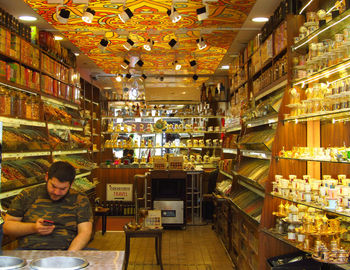 Man sitting in illuminated market