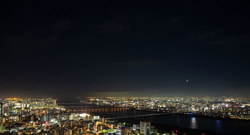 High angle view of illuminated buildings against sky at night