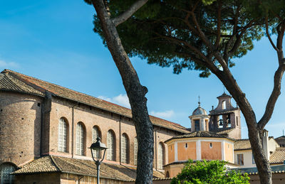 Low angle view of trees and building against sky