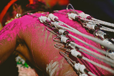 Rear view of shirtless man with pierced back during thaipusam
