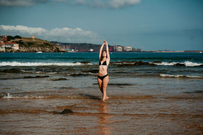 Full length of woman at beach against sky
