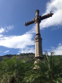 Low angle view of cross on field against sky