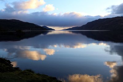 Scenic view of lake by mountains against sky