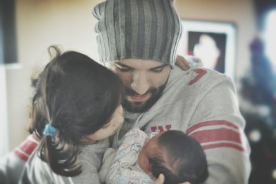 Close-up of father with daughter and new born baby boy