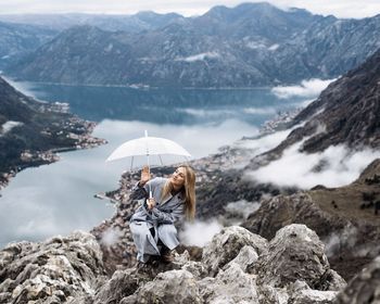 Woman on mountain range with umbrella 
