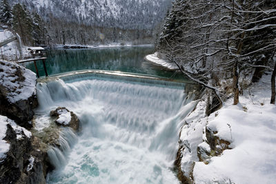 Scenic view of river flowing during winter