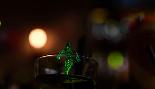 Close-up of illuminated glass bottle on table