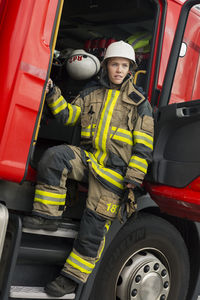 Female firefighter by fire engine