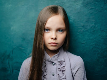 Portrait of girl against blue wall