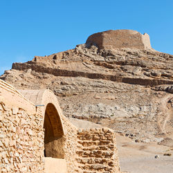 Low angle view of rock formation against clear blue sky