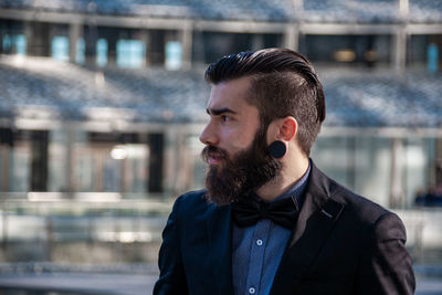 Portrait of young stylish hipster outdoors traveling through a european capital