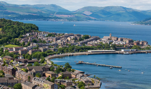 High angle view of city by sea against sky