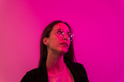 Portrait of beautiful woman against pink background