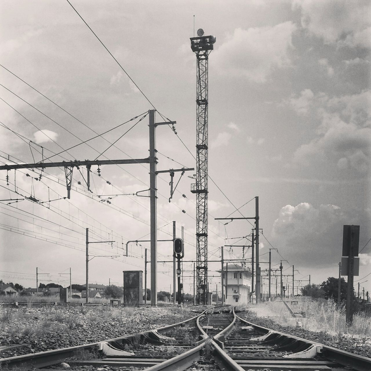 railroad track, transportation, electricity pylon, sky, power line, rail transportation, power supply, electricity, connection, cloud - sky, the way forward, built structure, road, fuel and power generation, cable, building exterior, architecture, public transportation, diminishing perspective, city