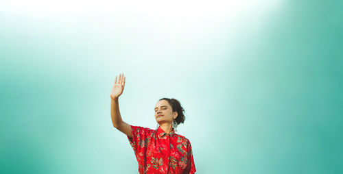 Full length of woman standing against blue background