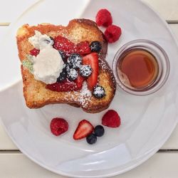 High angle view of strawberry on toasted bread in plate over table