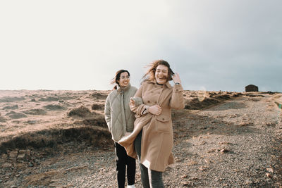 Full length of woman standing on field against sky