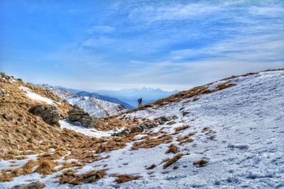 Scenic view of snowcapped mountains against blue sky