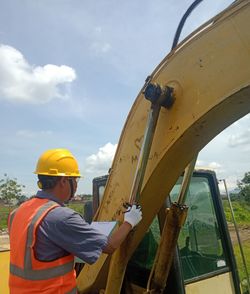 Low angle view of man working against sky