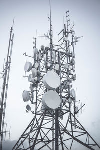 Low angle view of communications tower against sky