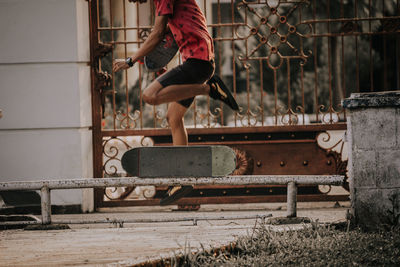 Low section of man skateboarding by gate