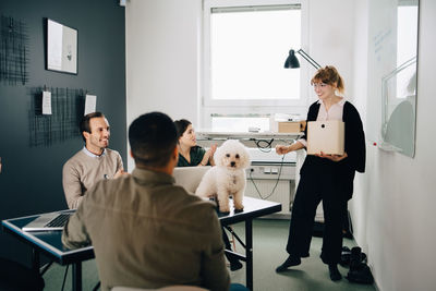 Smiling multi-ethnic business colleagues discussing in board room at creative office