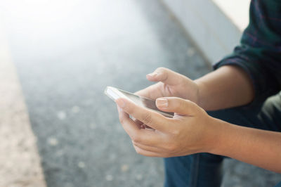 Midsection of man using mobile phone