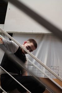 Portrait of young man sitting on staircase