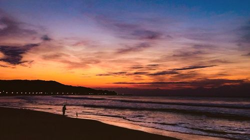 View of calm beach at sunset