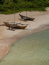 Boat moored on shore at beach