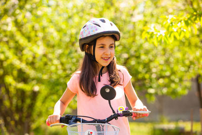 Cute girl riding bicycle outdoors