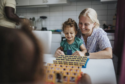 Mother and daughter spending time together playing game at home