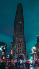 Low angle view of illuminated buildings against sky at night