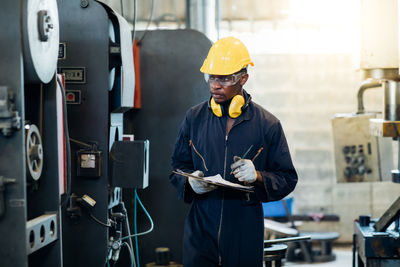 Man analyzing machines in factory