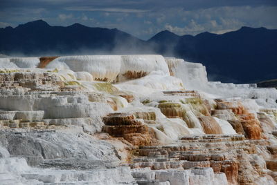 Mammoth hot springs in yellowstone with mountains in the background