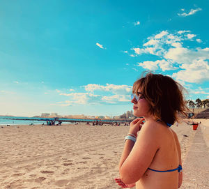 Young woman looking at sea against sky vacations beach