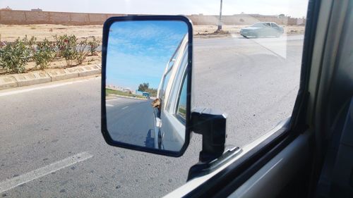 Reflection of road in side-view mirror of car
