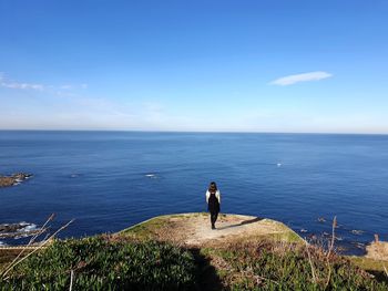 Woman looking at sea against sky