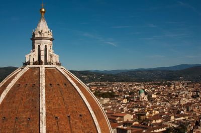 High section of dome overlooking cityscape against blue sky