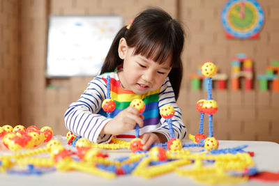 Cute girl playing with toy at home