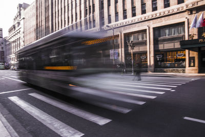 Blurred motion of bus on road in city