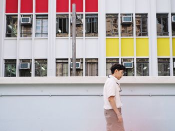 Side view of woman standing outside building