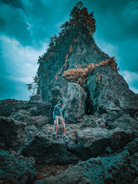 People standing on rock against sky