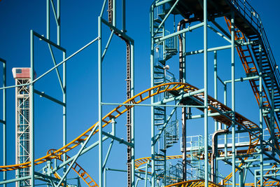 Low angle view of ferris wheel against blue sky