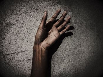 Cropped hand of person against wall