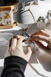 Crop seamstress using sewing machine in workshop