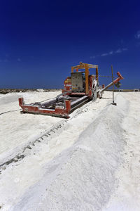 Construction site on shore against blue sky